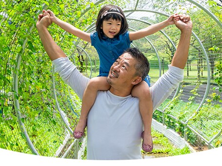 Smiling grandfather carrying his grandson on his shoulders