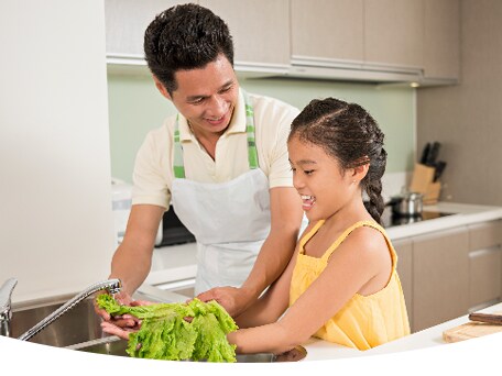 Father and her daughter preparing food together
